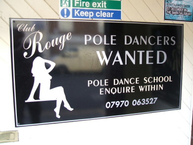 Funny sign along the street in Salisbury, England. School for strippers. Pole dancing school.
