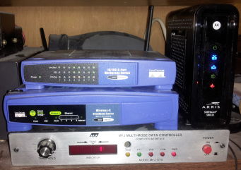 Cisco EZXS88W Ethernet switch, Cisco WRT54G wireless router and Ethernet switch, Harris SB621 'Surfboard' cable modem, MFJ-1278 multi-mode data controller.