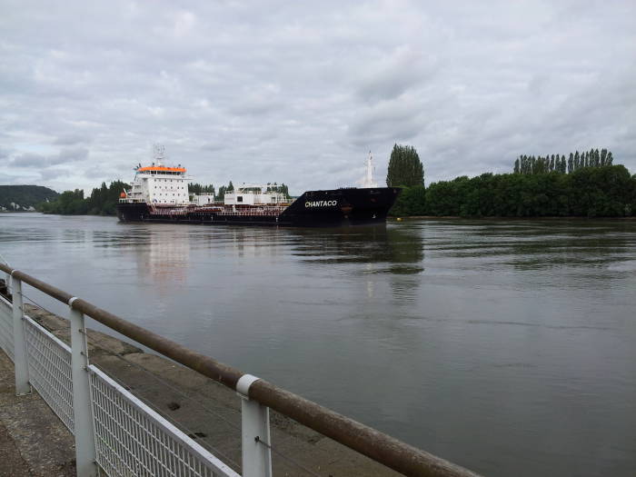 Ocean-going ship moving down the Seine river past Duclair.