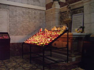 Candles and devotional plaques in the basilica.