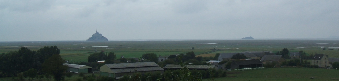 Mont-Saint-Michel and Tombelaine rise out of the tidal mud flats as seem from a distance.