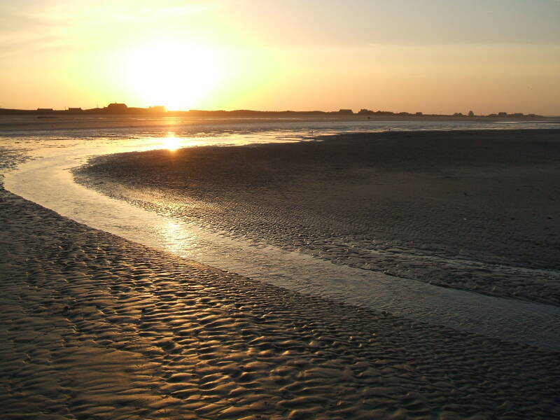 Sunset over Utah Beach. A small beach village in the distance.