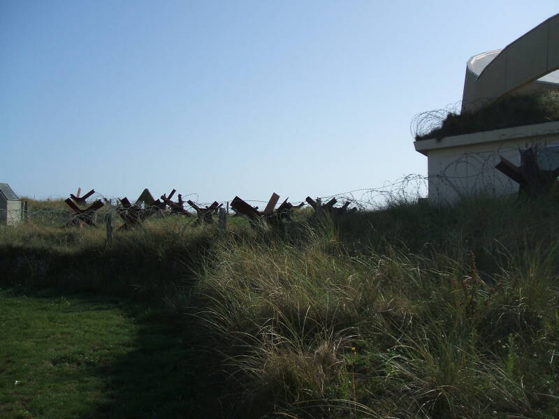 German defensive bunker and beach obstacles on Utah Beach, D-Day battlefield.