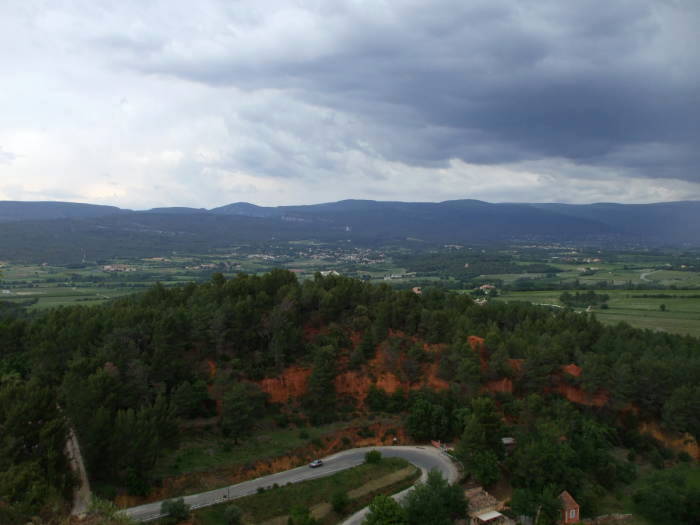 The D169 road runs up hill to Roussillon, northern Vaucluse valley in the background.