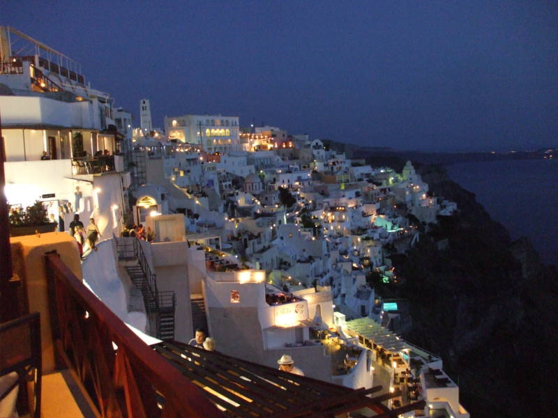 Lights come on after sunset on Santorini.