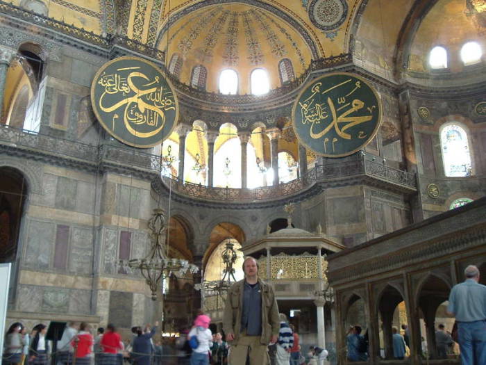 Interior of the Hagia Sophia or Aya Sofya, in Istanbul.  Mosaic of the Virgin Mary and Jesus in a large semi-dome over the altar area.  Mihrab showing the direction to Mecca.  Minbar or pulpit from which the Imam delivers the sermon.  Large medallions with Koranic quotes in large calligraphy.