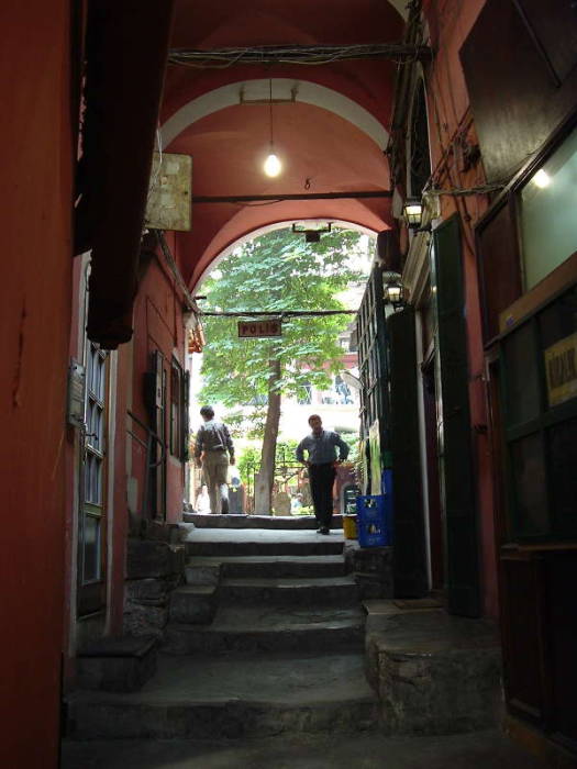 Passageway leading to Zincirli Han within the Grand Bazaar in Istanbul. Steps leading up past a small tea shop to an open han.