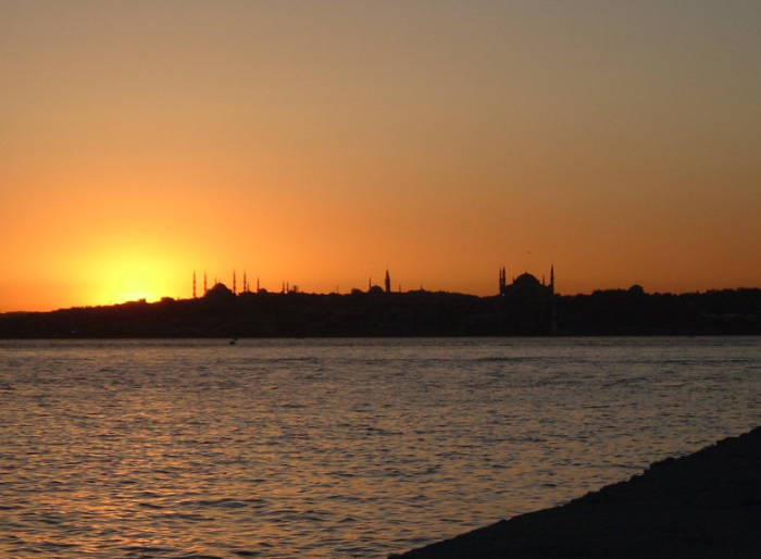 Sunset over the Bosphorus in Istanbul. The sun is setting over the Sultanahmet district as seen from the Asian shore.