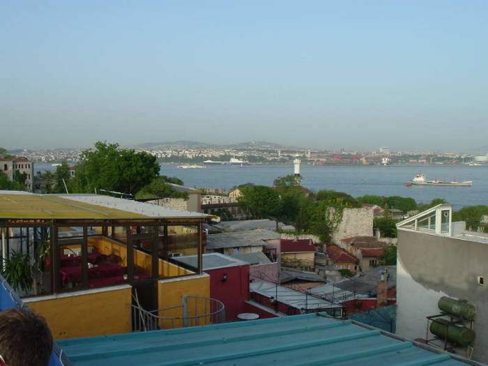 A view across the Bosphorus in Istanbul, from the Sultanahmet district to the Asian shore. A cargo ship is passing through the Bosphorus, beyond the lighthouse.