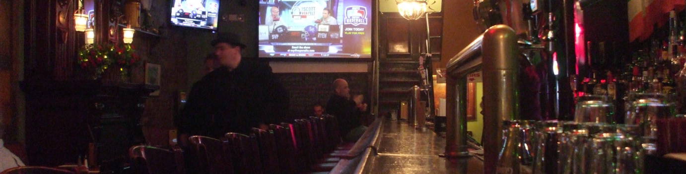 Interior of McGee's bar in New York, model for MacLaren's bar in 'How I Met Your Mother'. Looking down the bar on the first floor: bar stools, booths at left, sports on flat-screen TVs, taps and glasses.