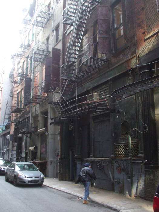 A man walks along Cortlandt Alley.