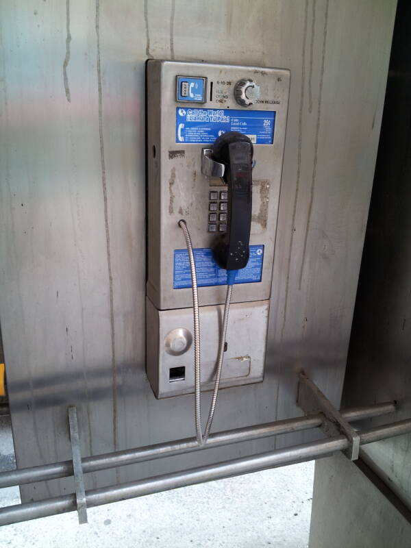 Relatively modern phone booth, enclosure starts about waist-high, standard square buttons.