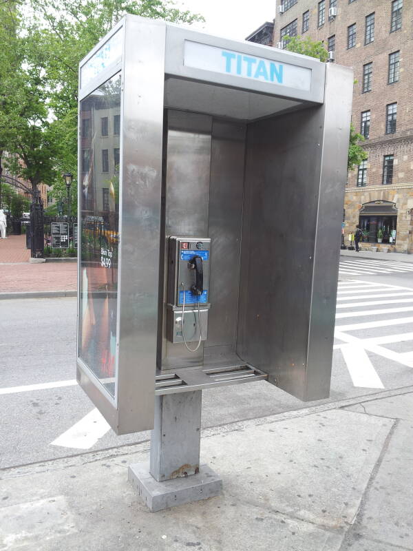 Relatively modern phone booth, enclosure starts about waist-high, standard square buttons.