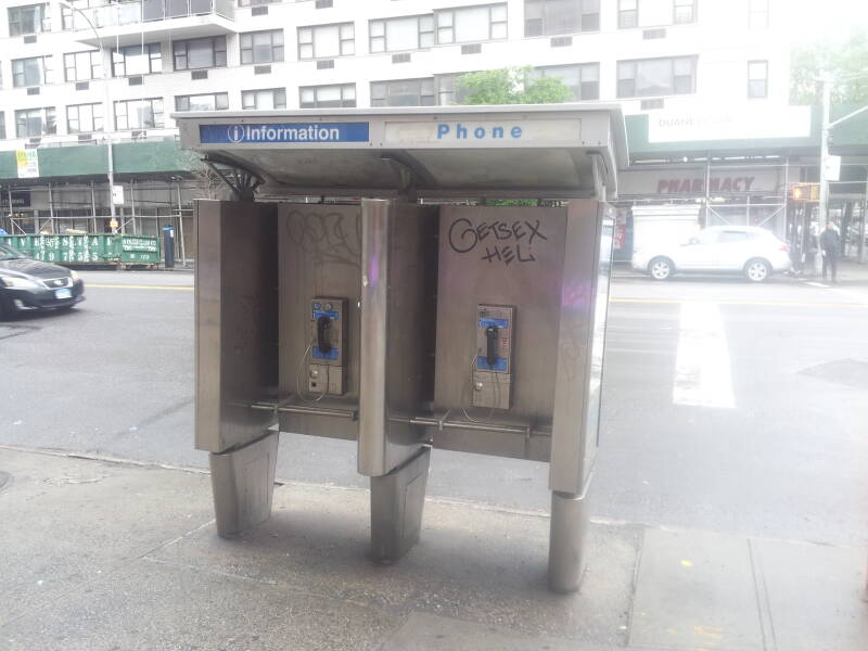 Relatively modern phone booth, enclosure starts about waist-high, relatively, small pin buttons.