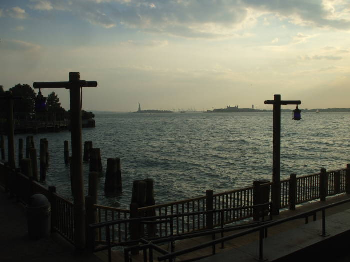 South on the bike path along Hudson River Park, Statue of Liberty and Ellis Island, Port of New Jersey in the background.